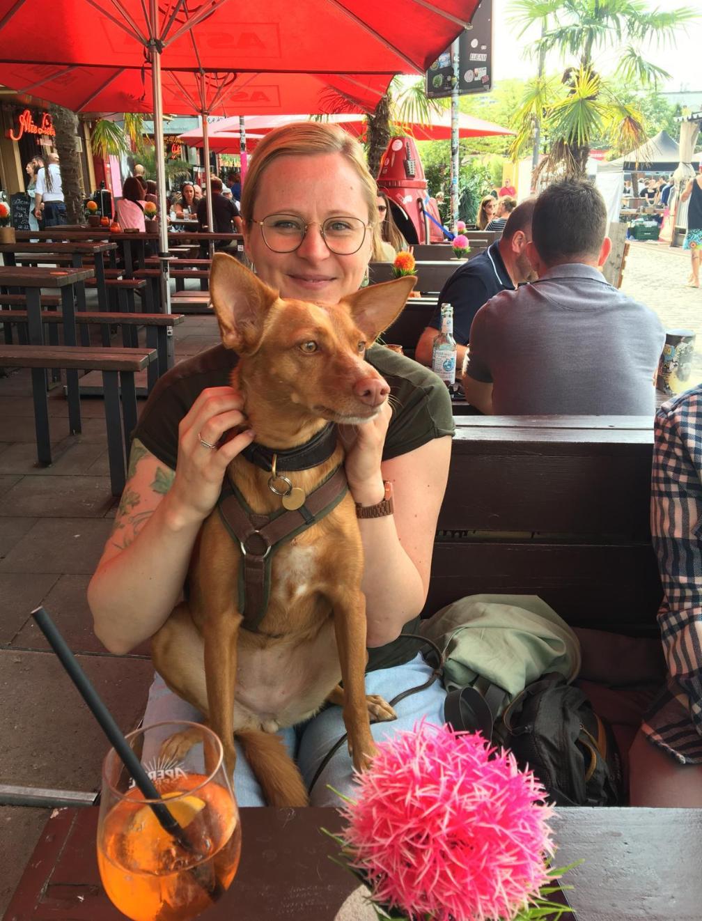 Caro mit Maggie auf dem Schoß in einem Biergarten